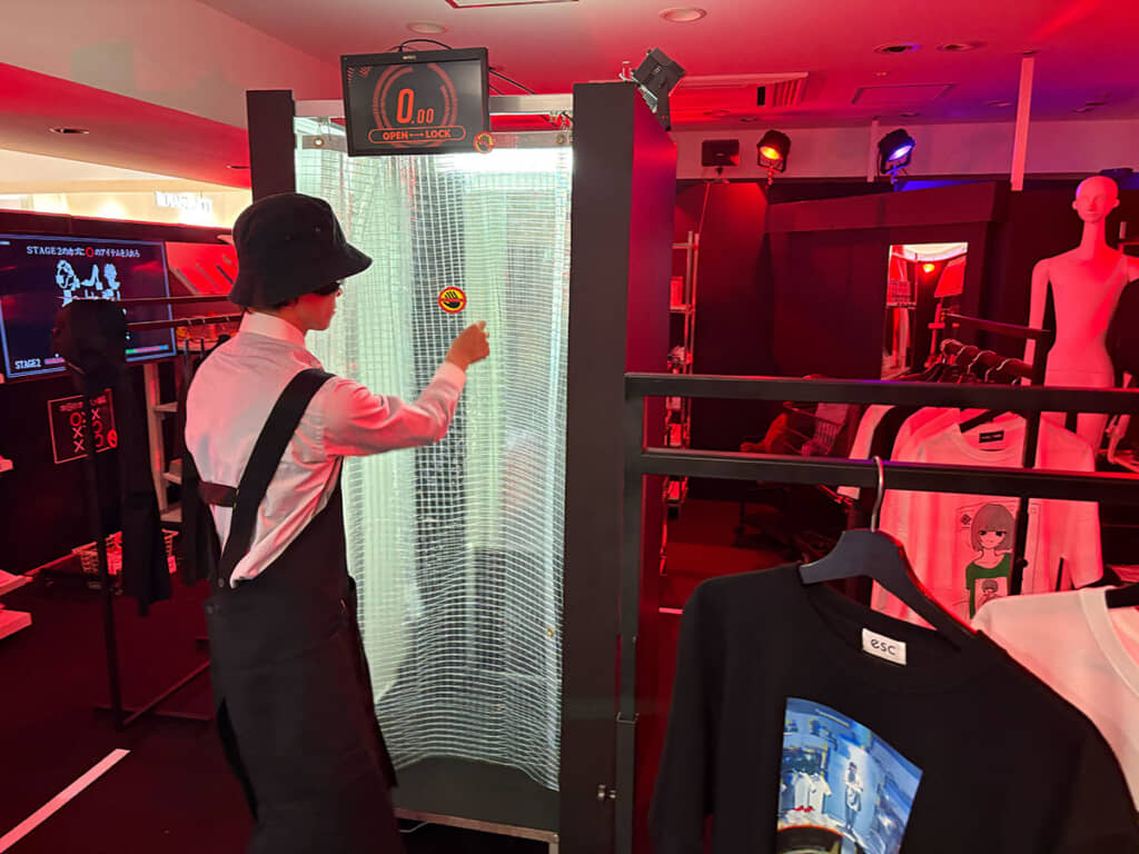 更衣室のカーテンにストップマークをぺたりとする店員