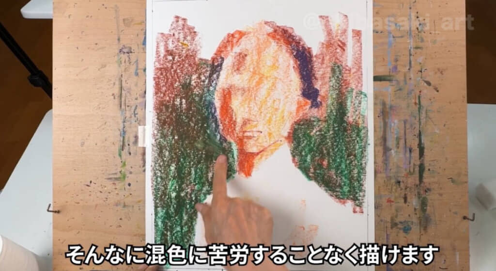 背景に濃い色を重ねて指でこすっていきます