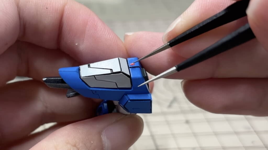 スジ彫り箇所にピンセットでパーツを接着する