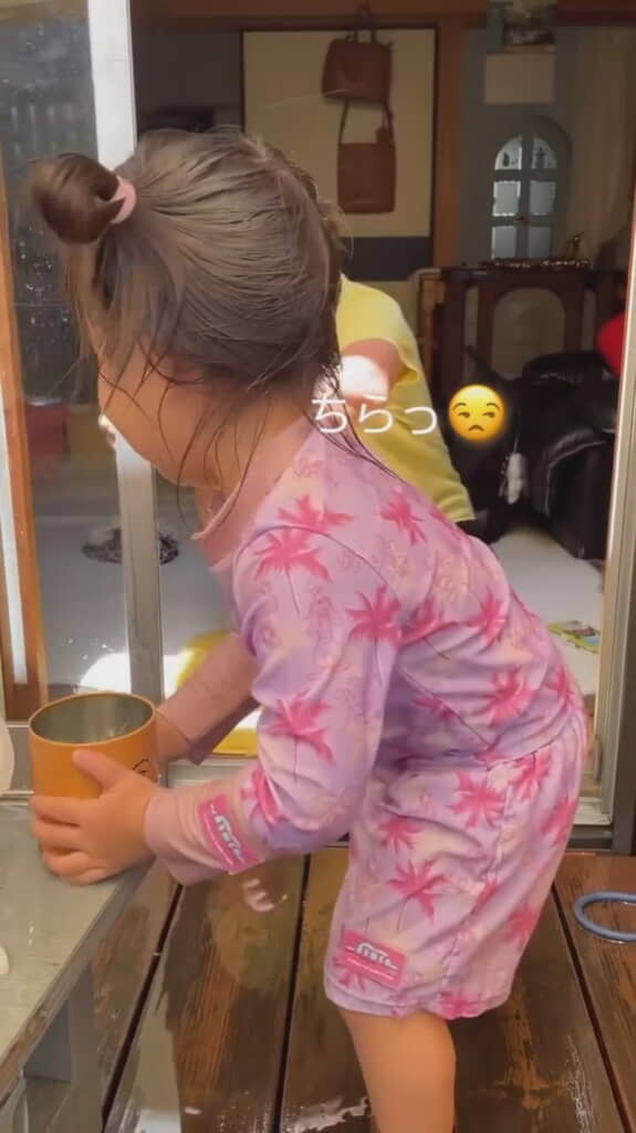 再度水の入った容器を手に取った娘さん