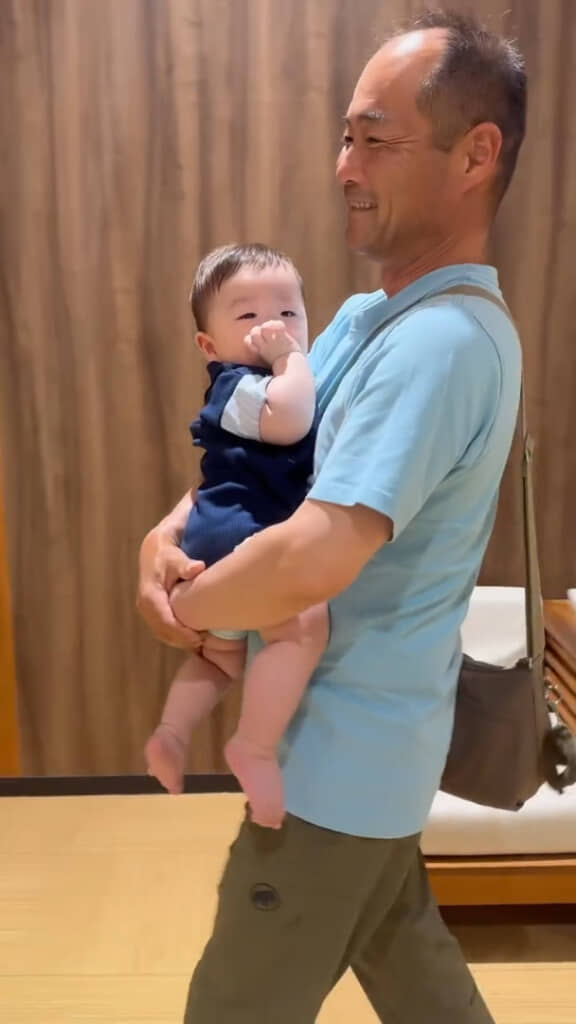 眠そうな孫のあいらしさに笑顔になるお父さん