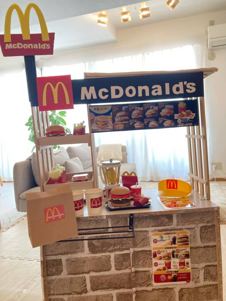室内に設置されたマクドナルド風の手作りごっこ遊びブースと、おもちゃの食品類が並ぶカウンターの全景