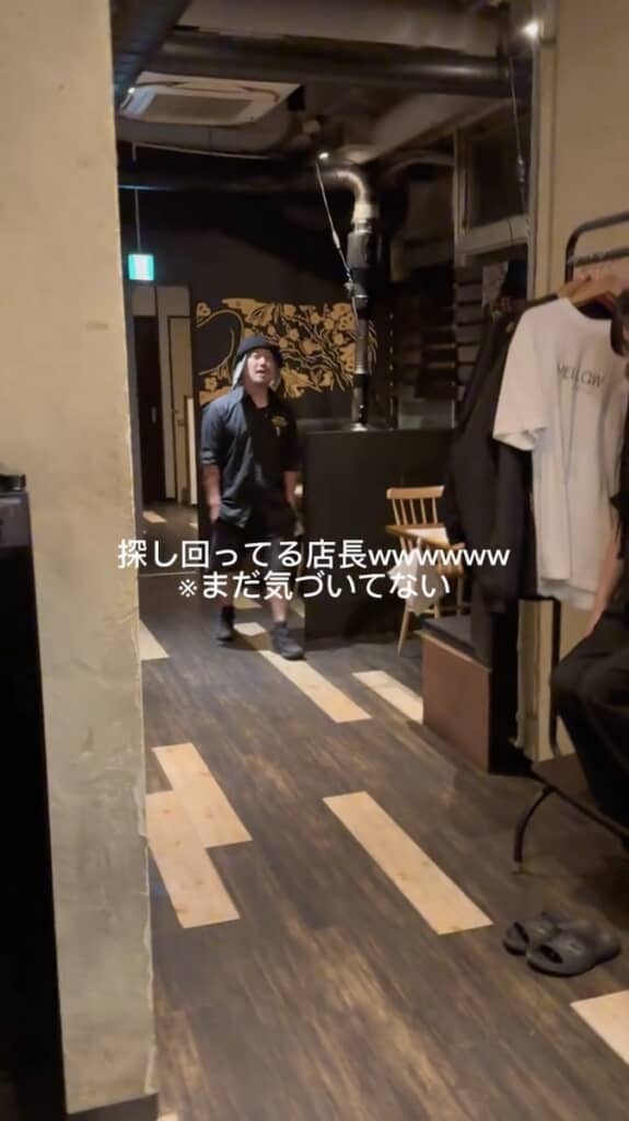 ハンガーラックに近づいてくる店長