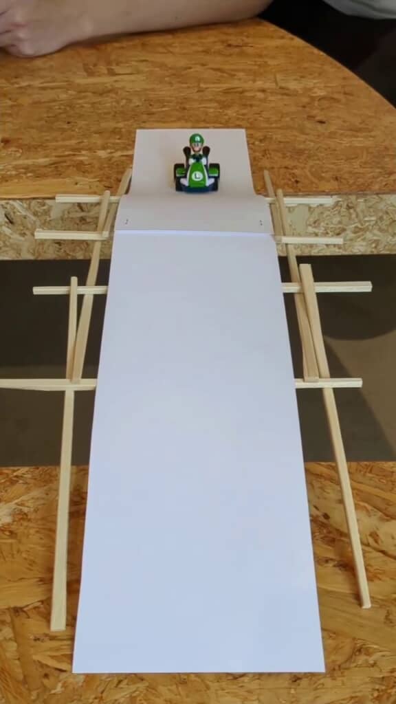 10本の割り箸で組んだ橋を移動するルイージ