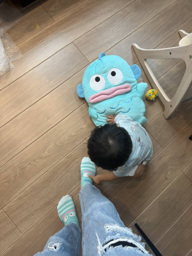 ママの足元にいるハンギョドンを指さす娘