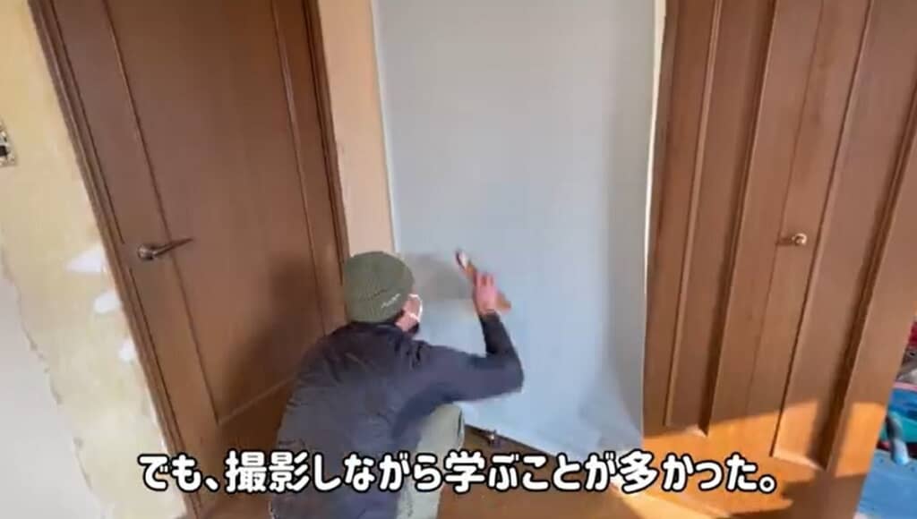 夫が青色の壁紙を貼ります