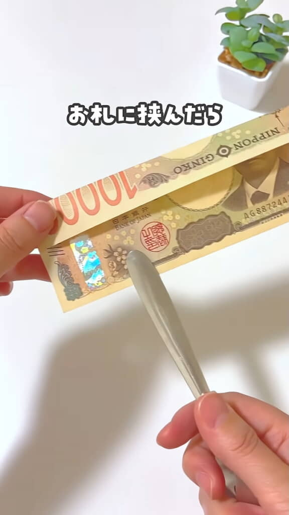 紙幣をはさんで突き刺すように動かすと貫通したように見える