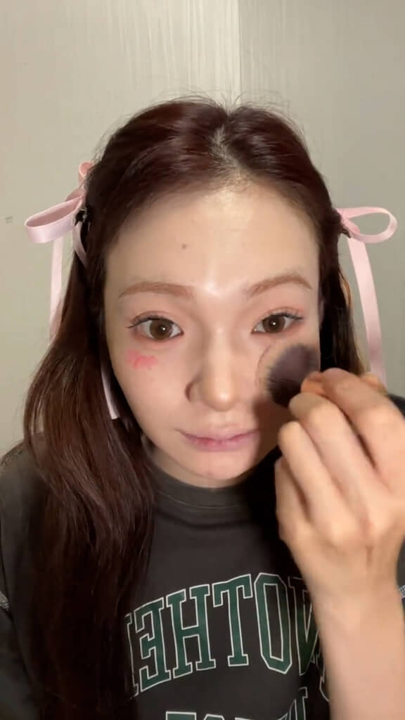 チークを頬に広めにのせて