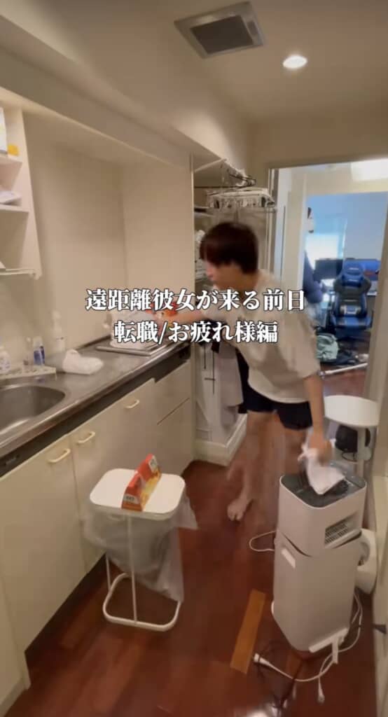 廊下のキッチンで床掃除をする男性