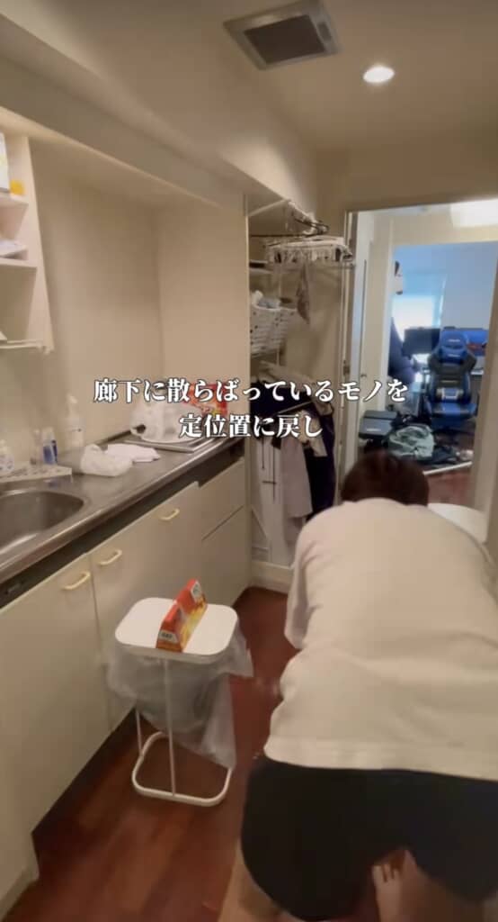 キッチン付きの廊下で片付け作業をする男性