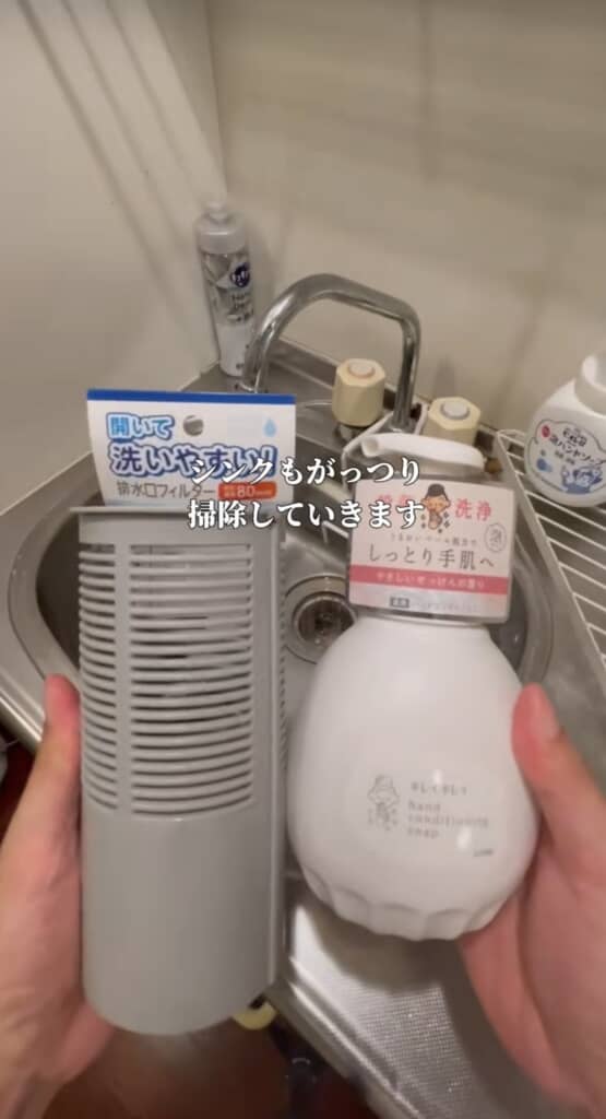 浴室用の排水口フィルターと「キレイキレイ」ハンドソープを持ってシンク掃除の準備をする様子。