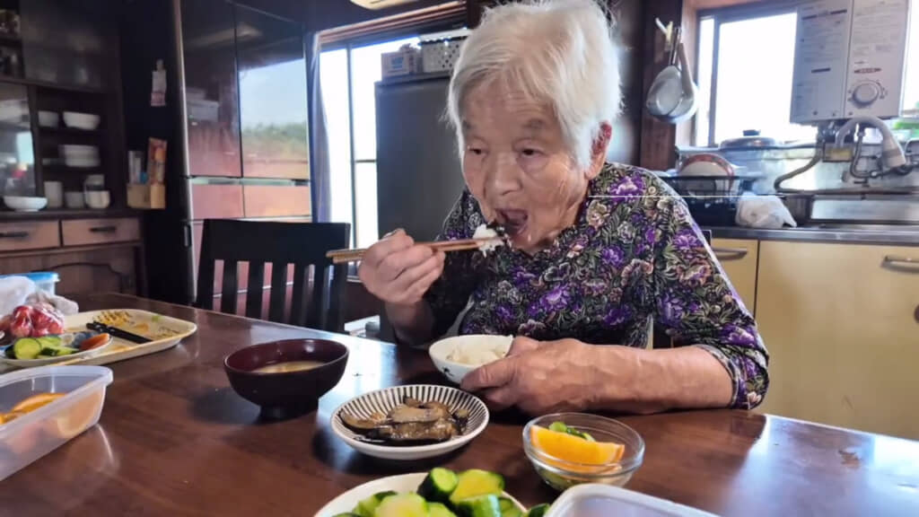 自分で作った料理を元気に食べるおばあちゃん