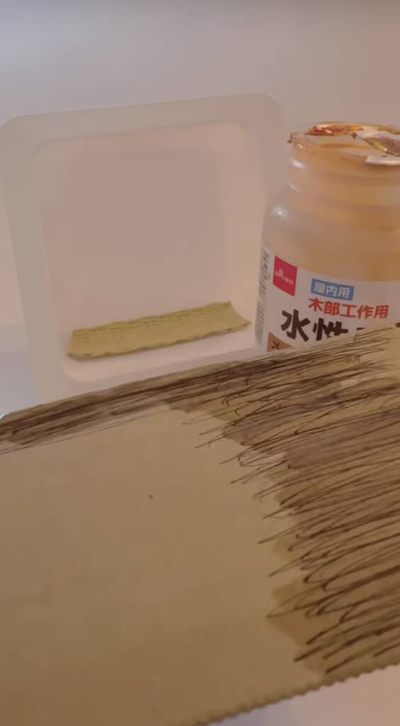 ダイソーの水性ニスを使って段ボールに着色している様子。