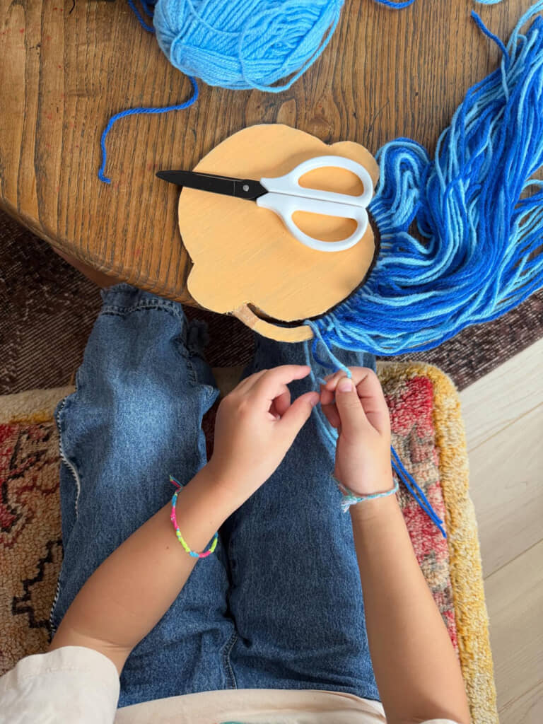 髪の毛に見立てた毛糸を結びます