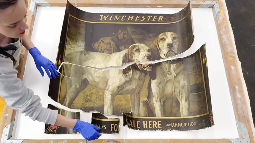 作業台の上で、破れたパーツを慎重に組み合わせている様子