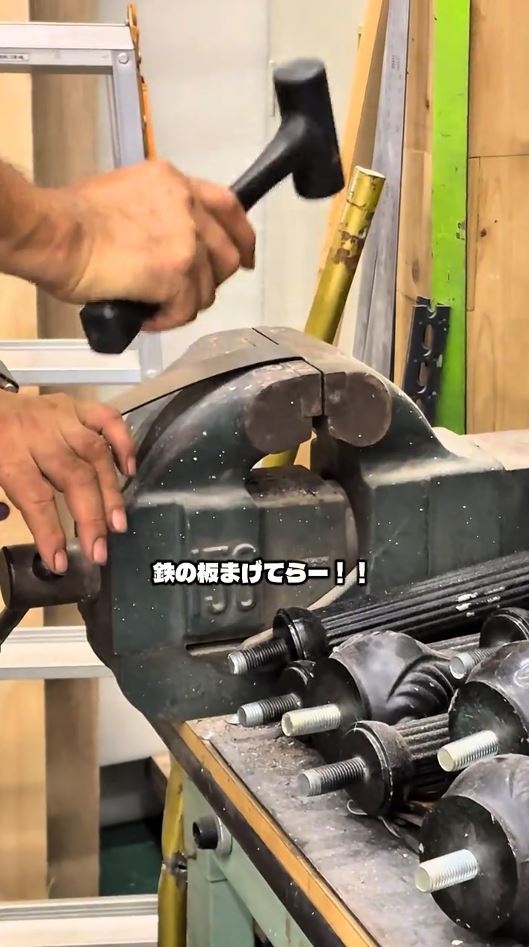 鉄の板をまげている父