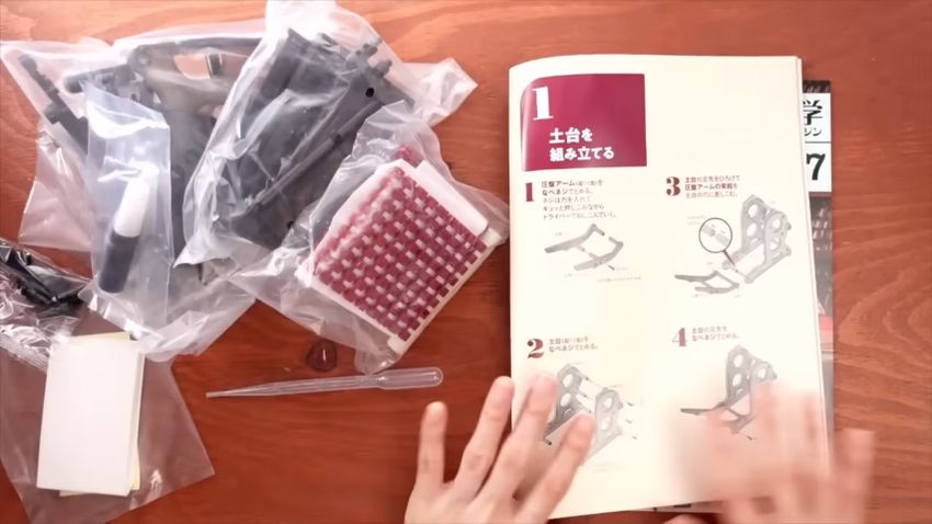 組み立て方のページと小さな活版印刷機の部品