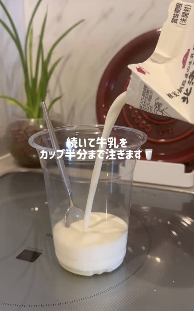 牛乳を透明カップに注いでいる瞬間。