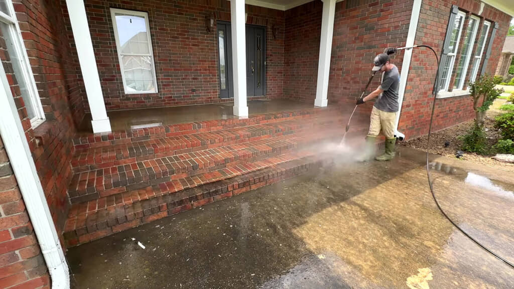 高圧洗浄機を当てると、黒ずんだ汚れが見る見るうちに剝がれていきます。