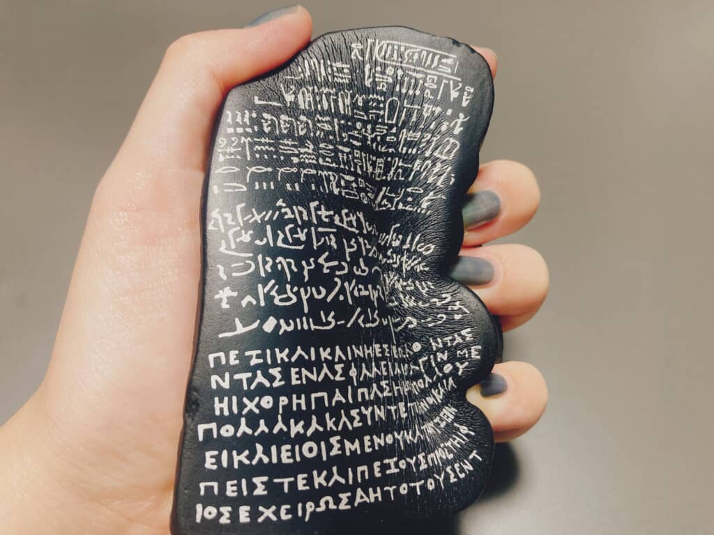 手に持たれたロゼッタストーン風の握れるオブジェ。