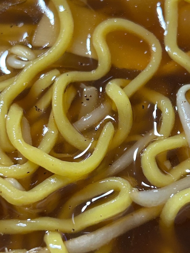 麺のすき間からこちらをじっと見つめる“顔らしきもの”を発見
