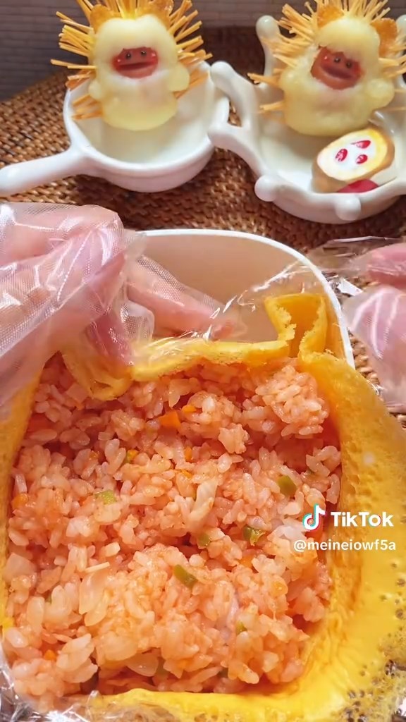 お弁当箱に薄焼き卵とチキンライスを詰め、ひっくり返してオムライスに