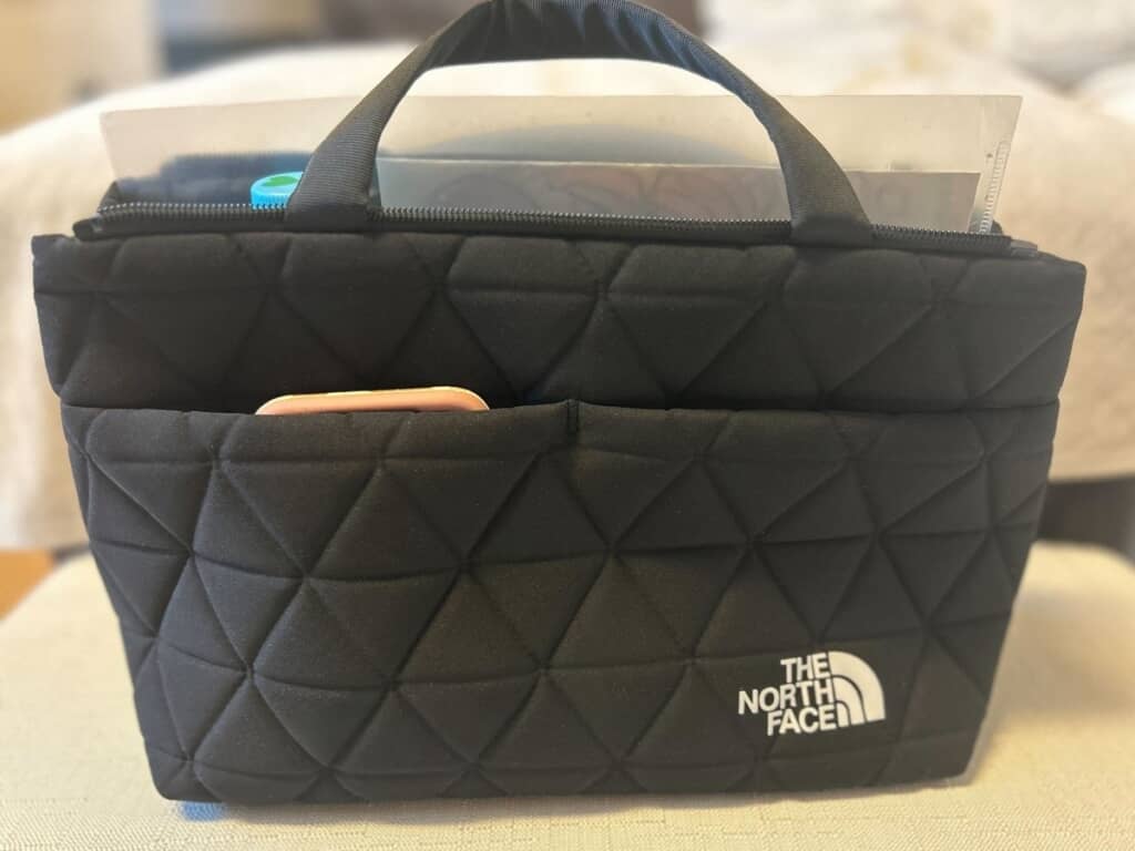 両サイドのスナップボタンを外して、600ミリリットルのペットボトルとA4クリアファイルを入れた状態　前ポケットにはスマホを