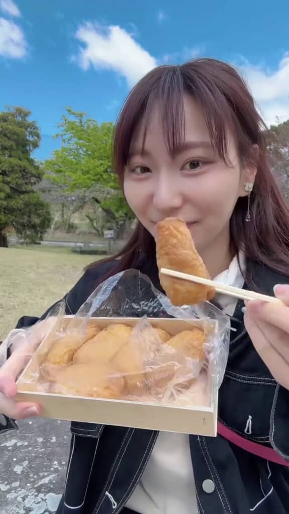 屋外でいなりずしを食べようとする投稿者