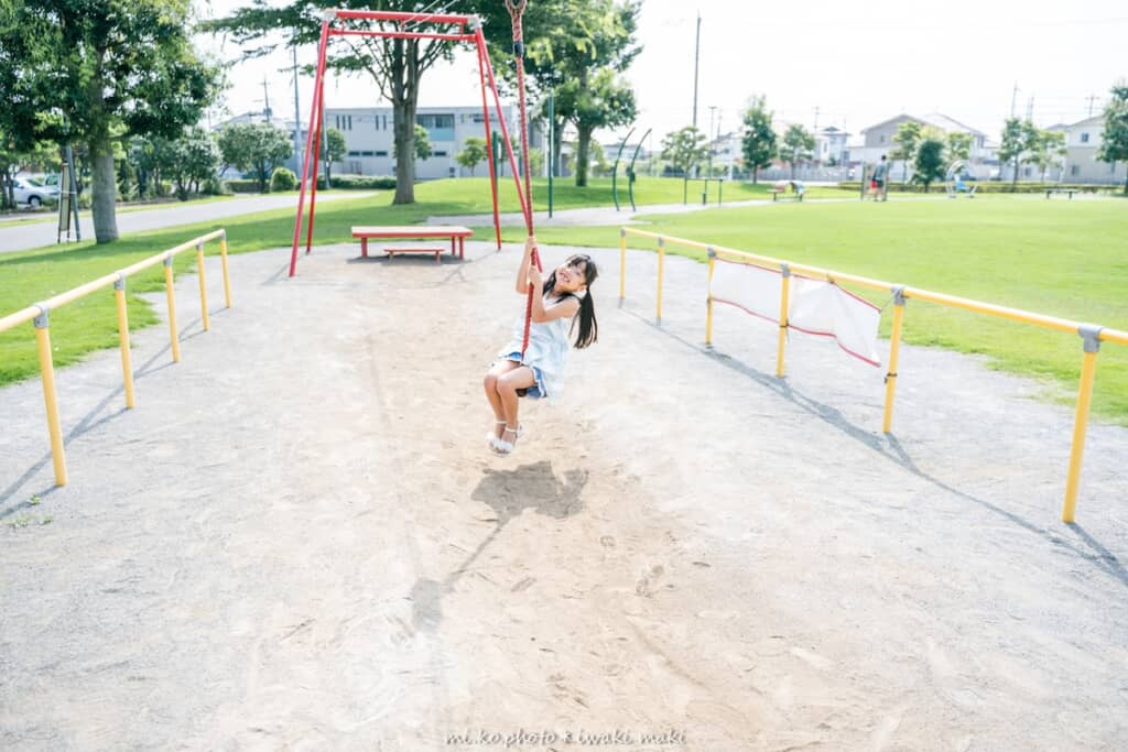 公園の遊具で遊ぶ娘さん