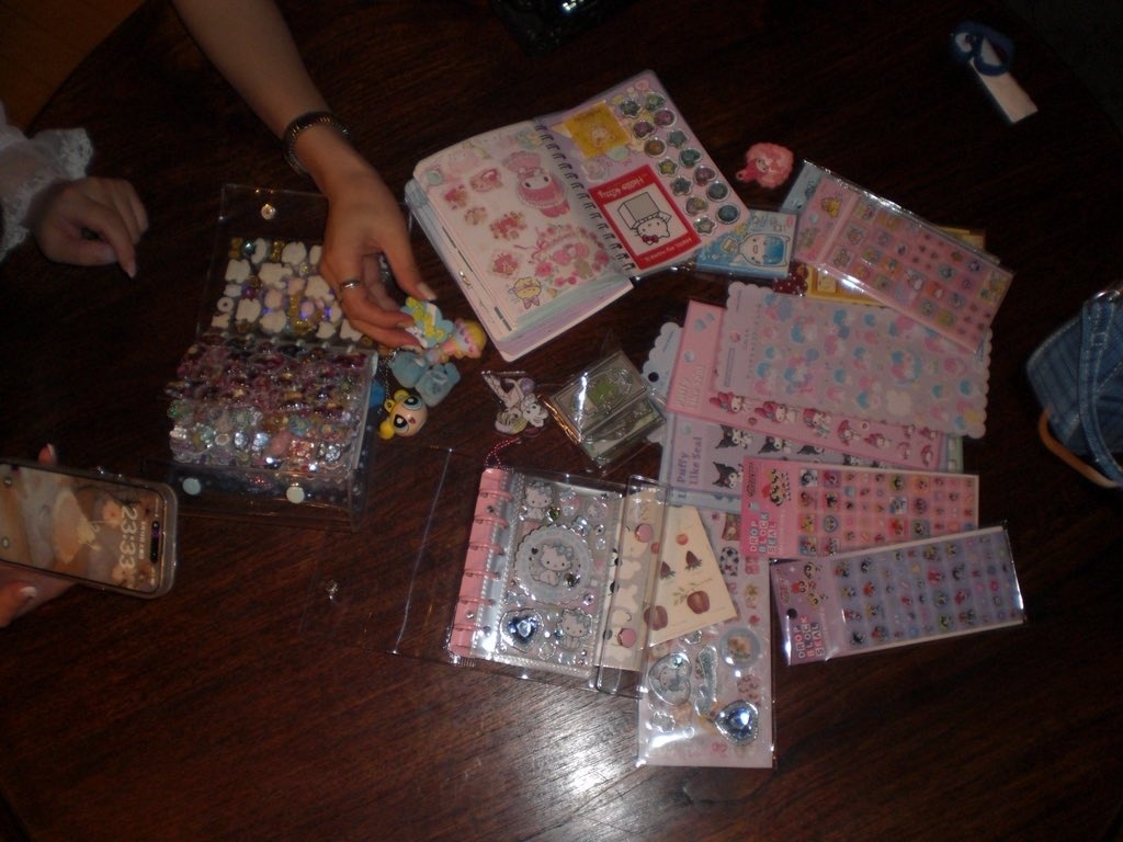 シール帳にサンリオキャラのシールを貼る様子