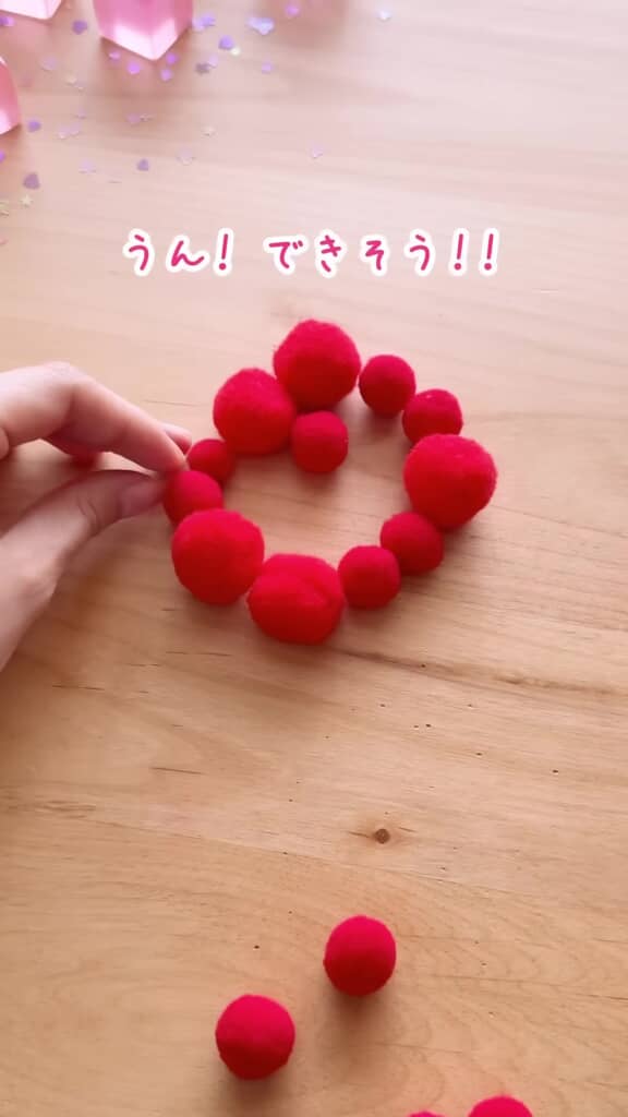 赤いポンポンを丸く並べている様子