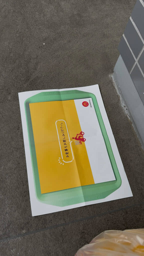 黄色と白の背景に赤い人物のイラストが描かれた敷き紙