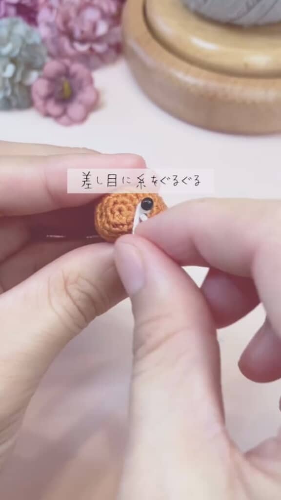 白い刺しゅう糸で目を固定