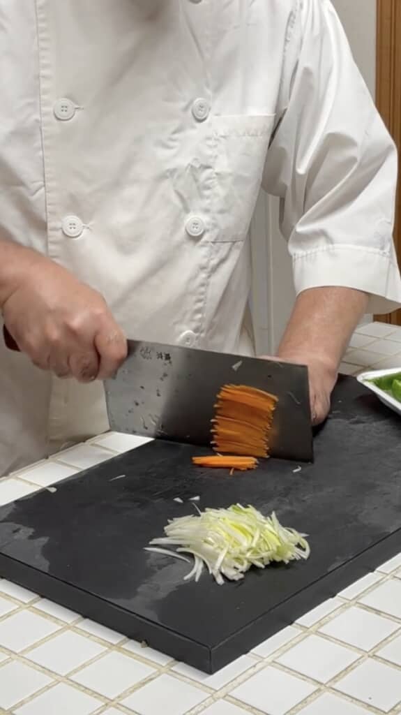 大きな中華包丁で野菜をみじん切り