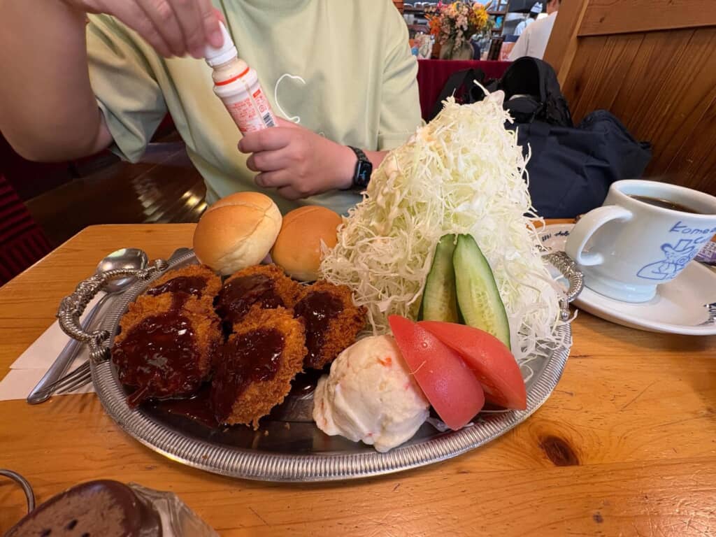 山盛りキャベツとヒレカツ、ロールパンが乗ったコメダ珈琲の食事プレート。