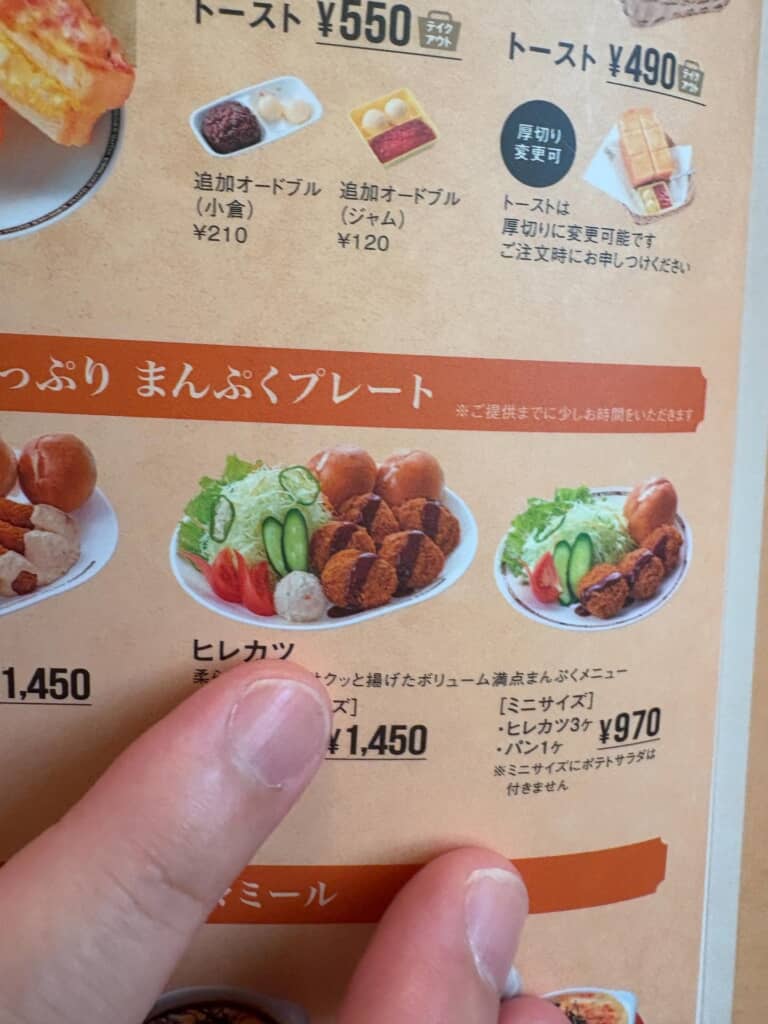 指で指し示されたコメダ珈琲のヒレカツプレートのメニュー画像。