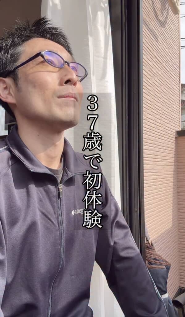 37歳で初体験と字幕が出ている男性が日差しの中で外を見つめている