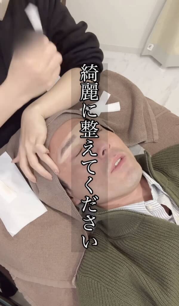 施術中の男性がベッドに横たわり、“綺麗に整えてください”という字幕が表示されている。