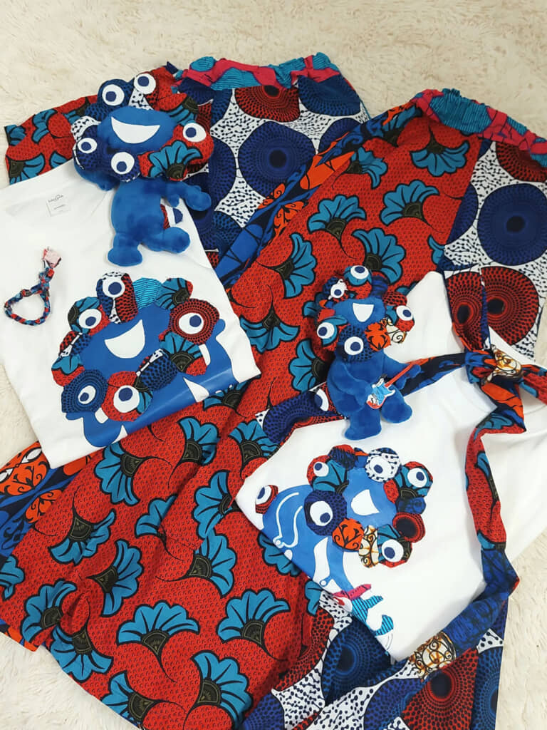 親子の万博コーデとミャクミャクぬいぐるみを並べて撮影。アフリカンファブリックの鮮やかな色柄が目を引く