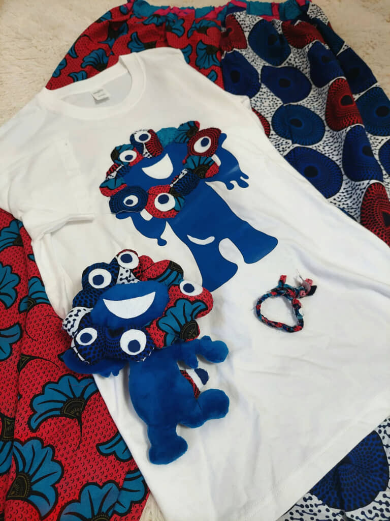 ミャクミャクが印刷されたTシャツにアフリカンファブリックをアップリケ。ぬいぐるみと一緒に撮影