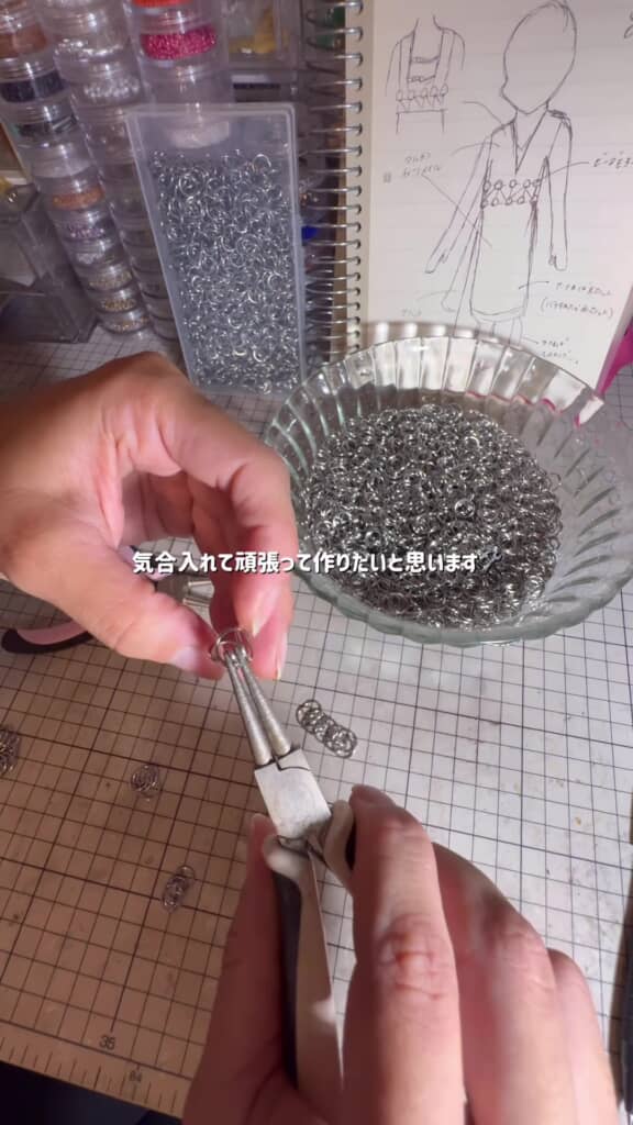丸カンドレス・机の上に並べられた銀色の丸カンとデザイン画。ペンチでつなぎます