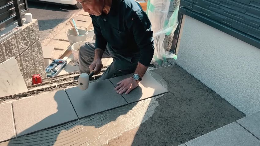 玄関へと続く階段にタイルを貼る様子