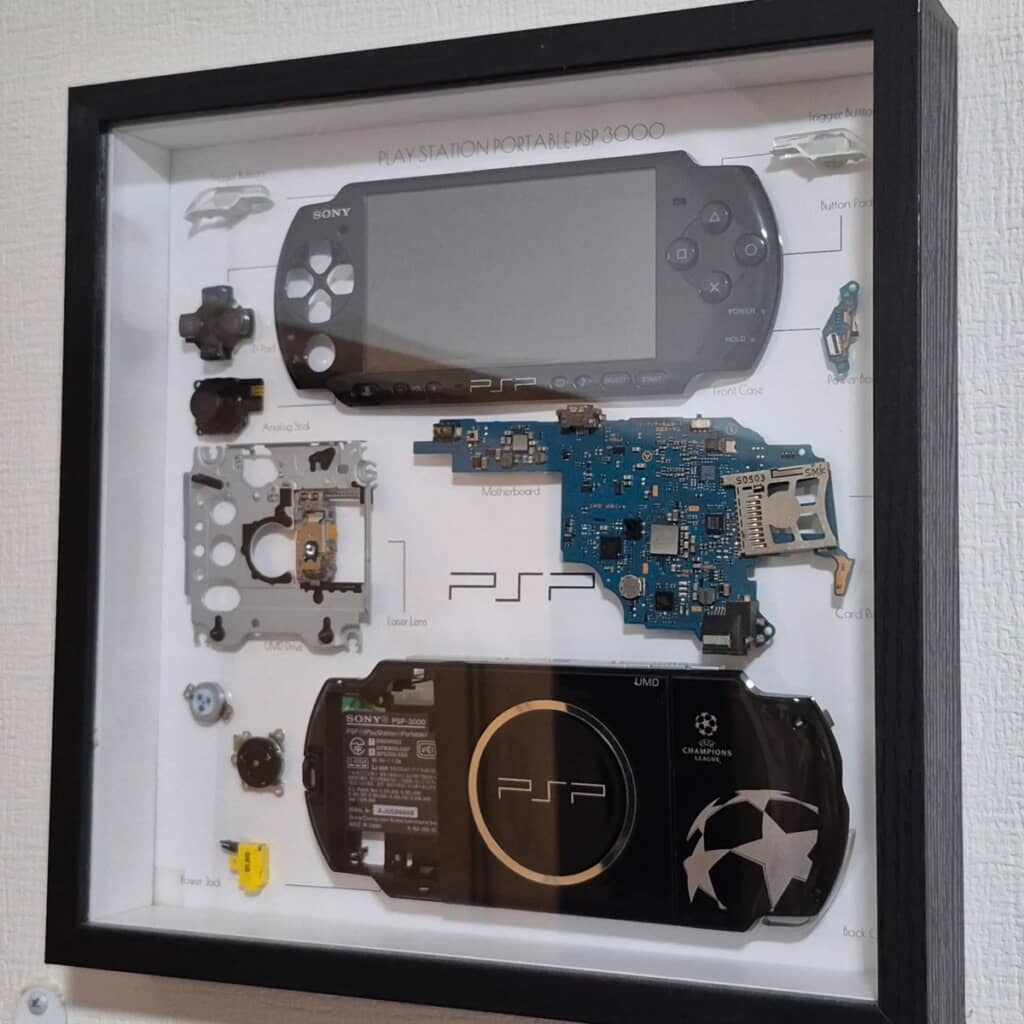 分解したPSPのパーツを額に入れた標本アート