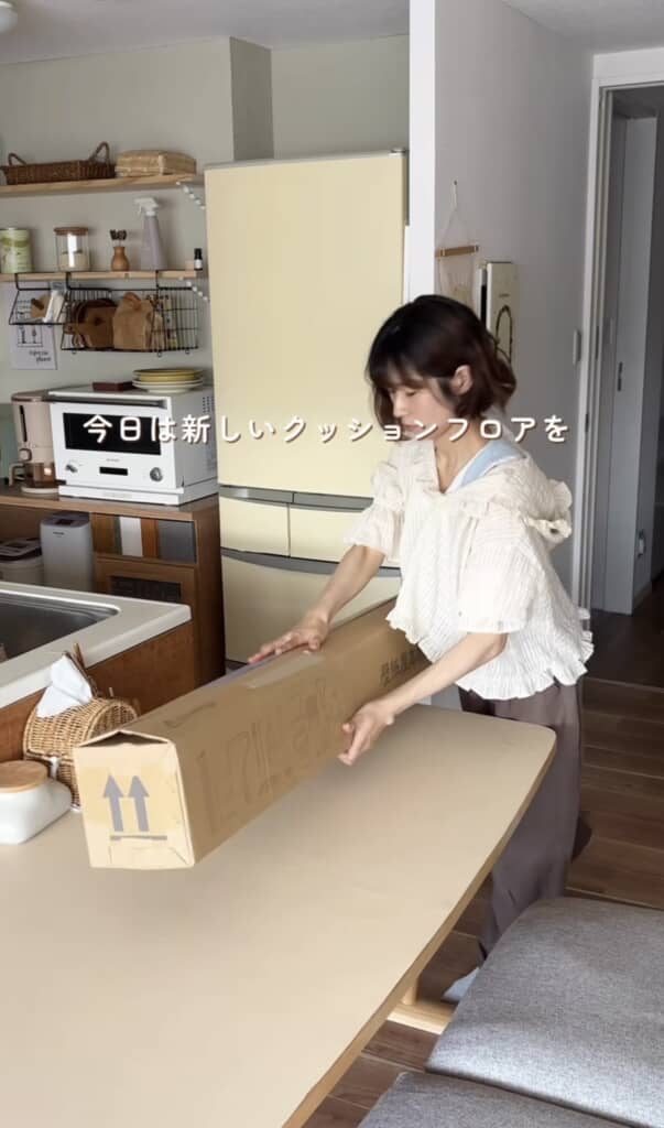 キッチンで新しいクッションフロアの箱を開ける女性