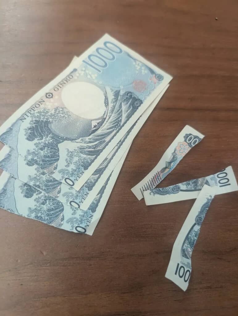 端が破れてしまった千円札3枚