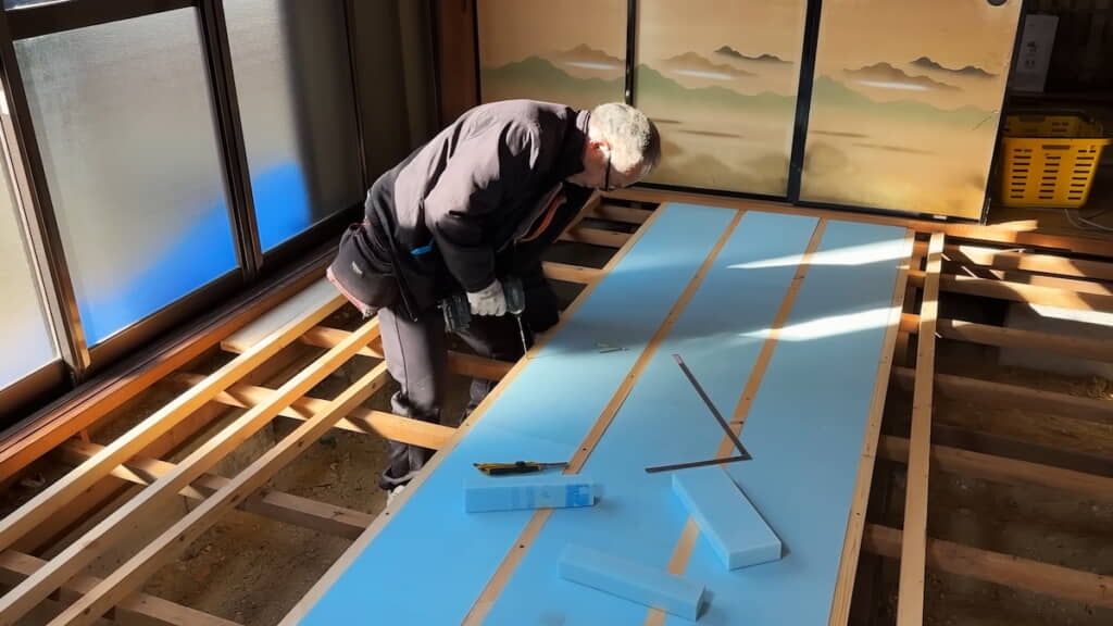 清水さんによる根太と断熱材の作業
