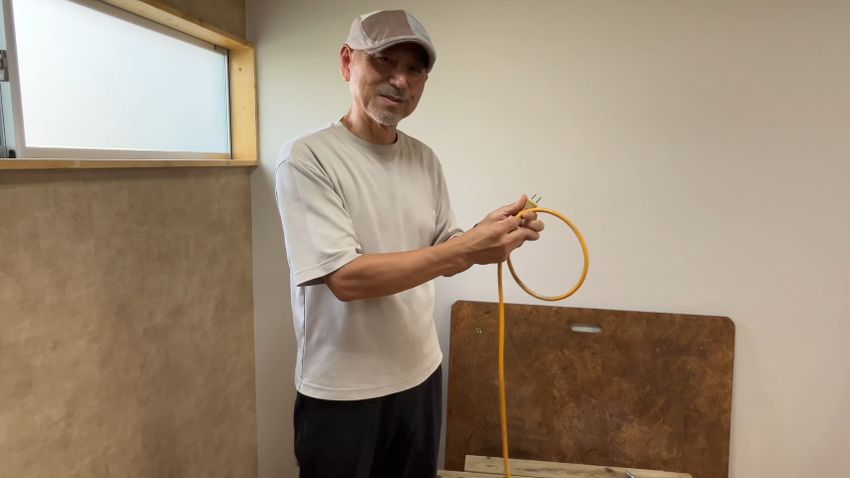 右手から左手へとコードを渡し、リング状にまとめる