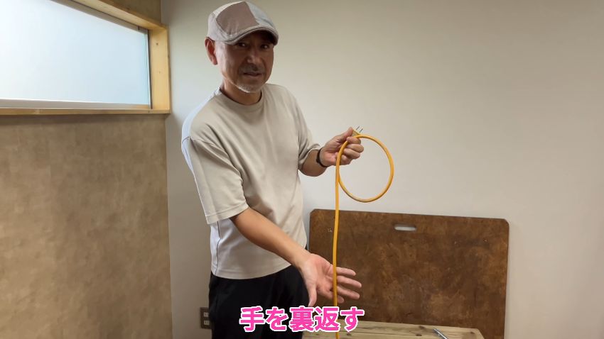 カメラに手のひらを向けてコードを握る