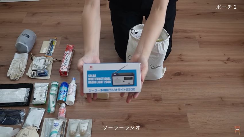 白い巾着袋に入っている太陽電池式のラジオ