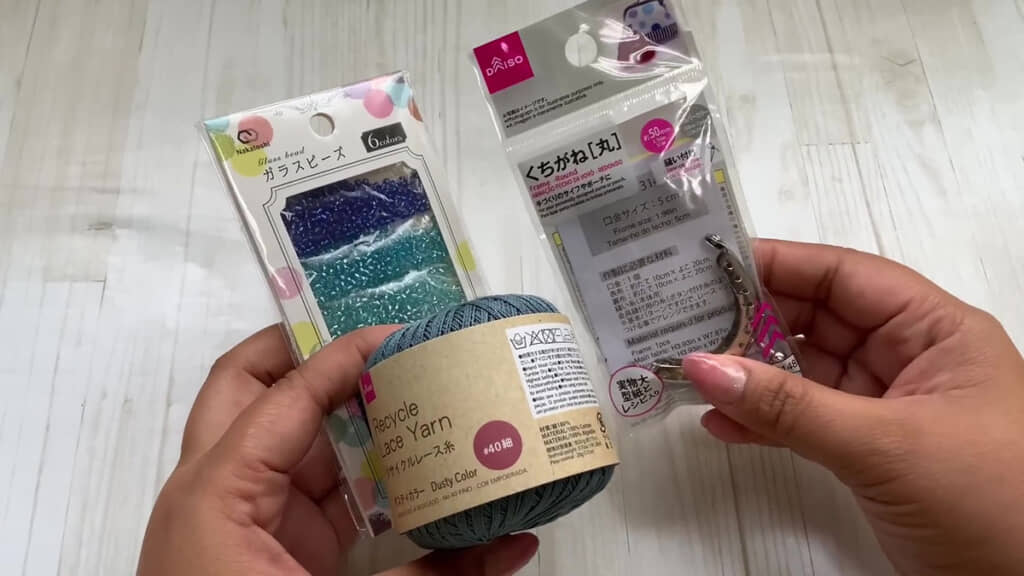 セリアのブルー系ガラスビーズとダイソーのレース糸、がま口を並べた写真